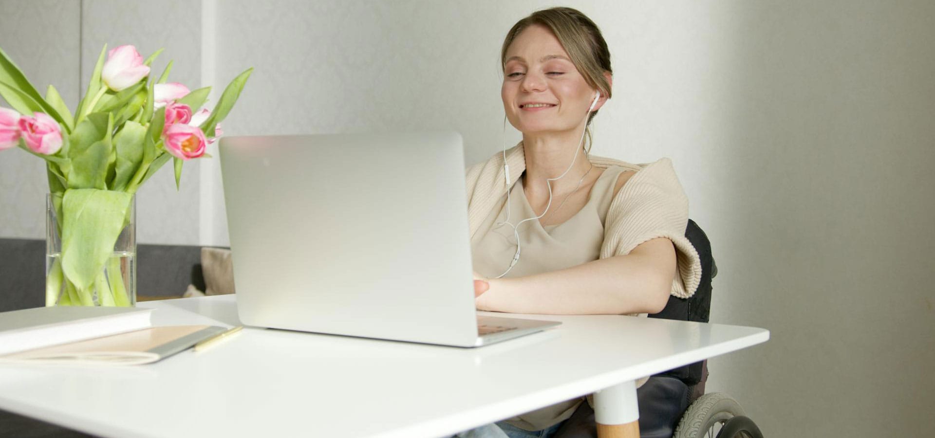 Kvinna sitter framför en bärbar dator vid sitt skrivbord